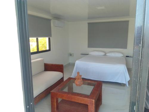 a bedroom with a bed and a couch and a table at Macao Sky pool Suite in Punta Cana