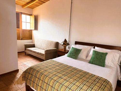 a bedroom with a bed with a couch and a chair at Casa Orígenes Hotel Boutique in Pamplona