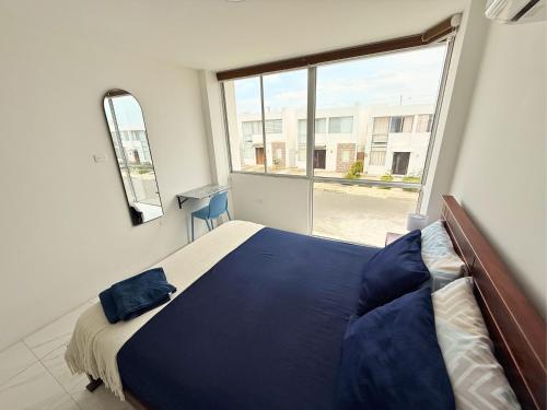 a bedroom with a bed and a large window at Casa Familiar a Pasos del Mar Playa y Felicidad in Manta