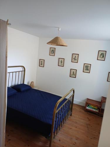 a bedroom with a blue bed and pictures on the wall at Betty in Saint-Gaudens