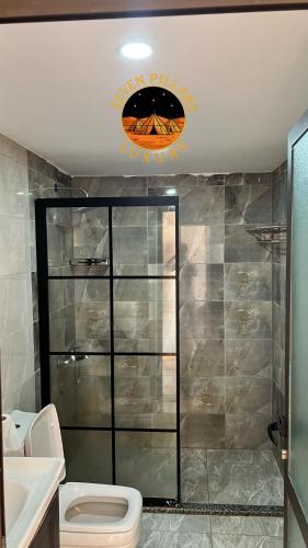 a bathroom with a toilet and a sign on the ceiling at SEVEN PILLARS lUXURY CAMP in Wadi Rum