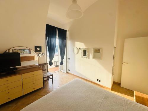 a bedroom with a bed and a dresser with a tv at PELAGOS - Agenzia Immobilevante in Ponza