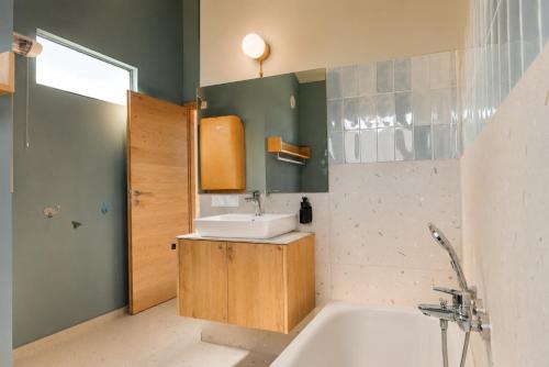 a bathroom with a sink and a bath tub at Das Kofelau in Oberammergau