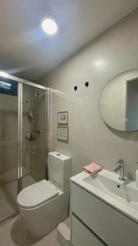 a bathroom with a toilet and a sink and a shower at Casa Miralago - Gerês in Admeus