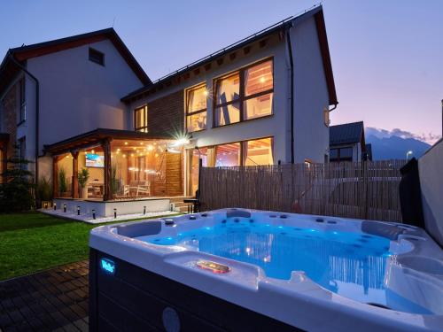 a large hot tub in front of a house at Chaletka Tatry in Nová Lesná