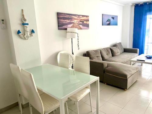 a living room with a glass table and a couch at APARTBEACH NARGAM Vista Playa in La Pineda