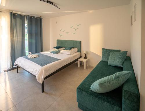 a bedroom with a bed and a couch at Victoria Ustka Pokoje i Apartamenty Blisko Plaży in Ustka