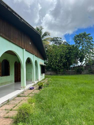 a green building with a grass field next to it at Villa Rapide in Ambanja