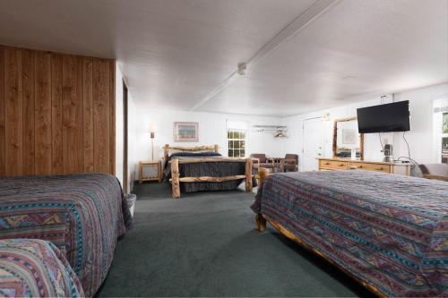 a hotel room with two beds and a flat screen tv at Marianna Inn Panguitch in Panguitch