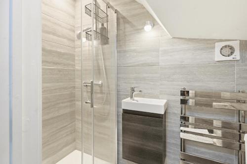 a bathroom with a shower and a sink at Park View En-Suite in Egham