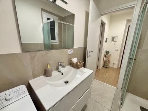 a white bathroom with a sink and a mirror at Sky House Sant'Orsola in Bergamo