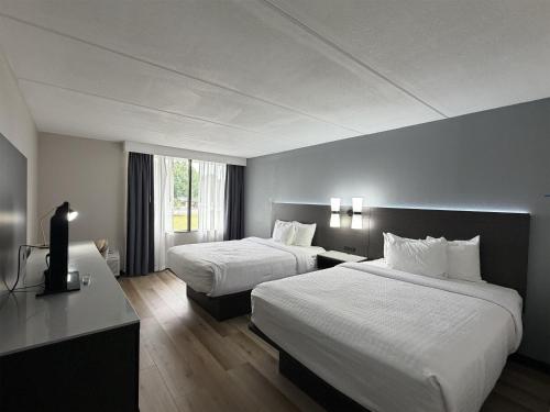 a hotel room with two beds and a television at SureStay by Best Western Charlotte Matthews in Matthews