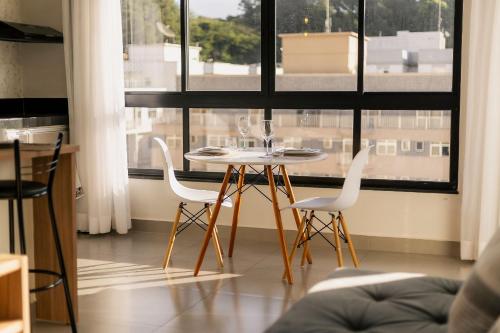 a table and chairs in a room with a window at Flats Diamond - Conforto, ed.novo e moderno localização impar in São Lourenço