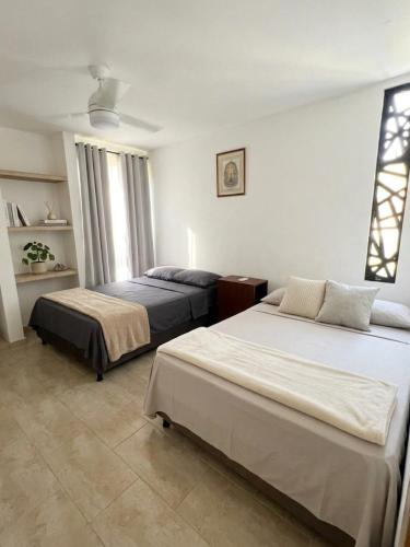 a bedroom with two beds and a window at Guantalamera Resort in Tubará