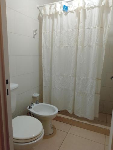 a bathroom with a toilet and a shower curtain at Casa Estadio con cochera in Santiago del Estero