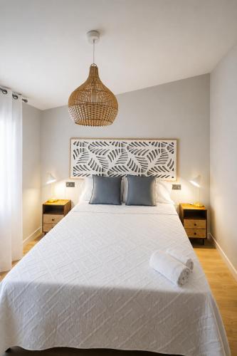 a bedroom with a large white bed with two night stands at Aurah Home in Tudela