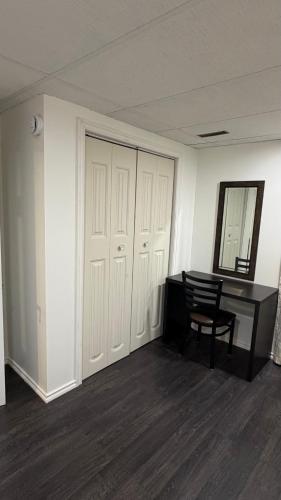 an empty room with a desk and a mirror at Velora Stays in Kelowna