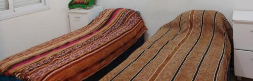 two beds sitting next to each other in a room at Casa Estadio con cochera in Santiago del Estero
