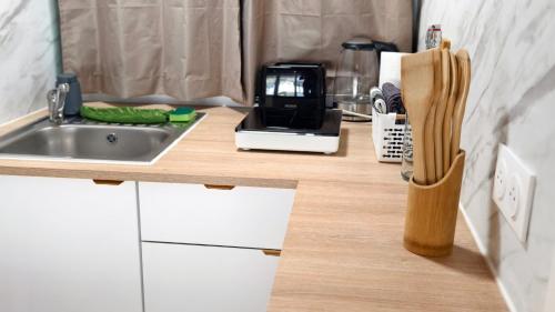 a kitchen counter with a sink and a microwave at Cozy studio in medieval town in Le Val