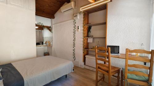 a bedroom with a bed and a desk and a chair at Cozy studio in medieval town in Le Val