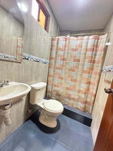 a bathroom with a toilet and a sink at "Wampu" - Amplio apartamento cerca del Centro Histórico in Cuenca