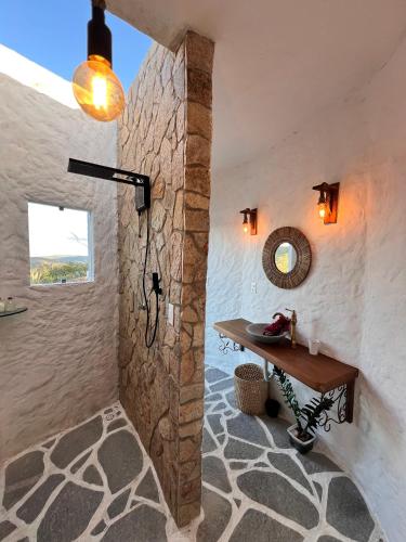 a bathroom with a stone wall and a table at Olymp Spa Boutique Hotel in Monte das Gameleiras