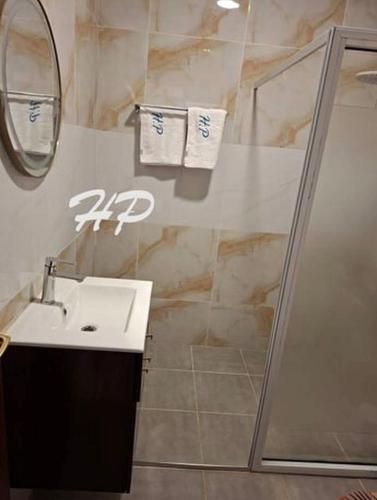 a bathroom with a sink and a shower at Hôtel Les Pyramides in Yaoundé