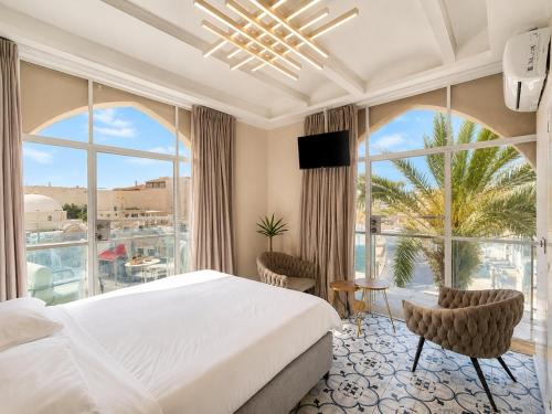 a bedroom with a bed and a large window at Safra - Hotel rooms in Tel Aviv
