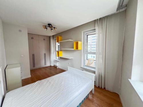 a white bedroom with a bed and a window at Mandala Garden Luxury Apartment in Ulaanbaatar