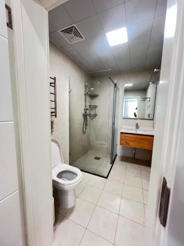 a bathroom with a shower and a toilet and a sink at Mandala Garden Luxury Apartment in Ulaanbaatar