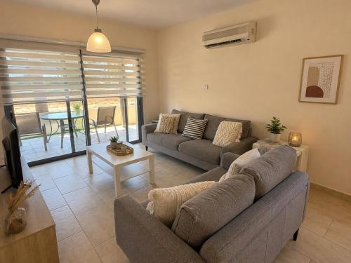 a living room with a couch and a table at Villa Paradise Complex - Pyla Larnaca in Pyla
