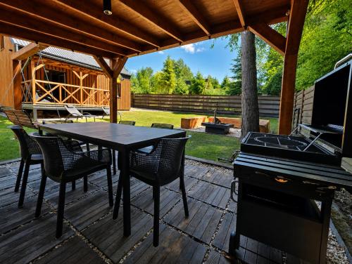 a patio with a table and chairs and a piano at Chëczka - 2min do Jeziora in Zbychowo