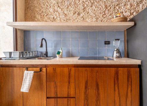 a kitchen with a sink and blue tiles on the wall at Casa Trova Santa Lucía with Parking by Cercana in Mérida