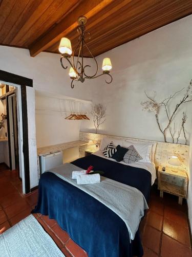 a bedroom with two beds and a chandelier at Casa Valldemossa in Búzios