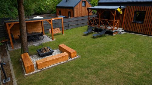 a backyard with a fire pit and a cabin at Chëczka - 2min do Jeziora in Zbychowo