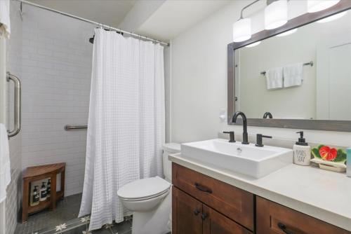 a white bathroom with a sink and a toilet at Puako Beach 309 Oceanview 3BR Condo in Waikoloa