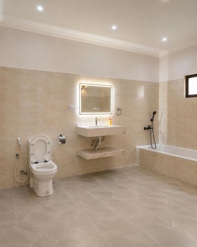 a bathroom with a toilet and a sink and a tub at Nanaa Hotel in Nungwi