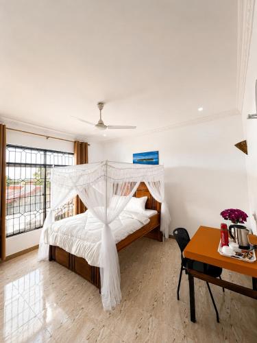 a bedroom with a bed with a canopy at Nanaa Hotel in Nungwi