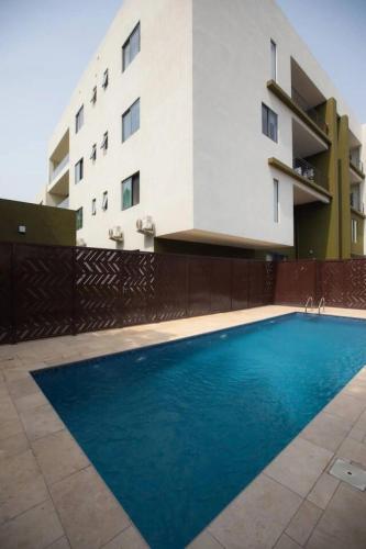 a swimming pool in front of a building at Wentworth - SKYSUITES in Accra