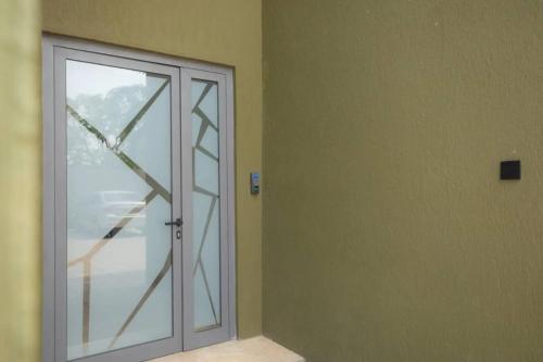 a sliding glass door in a room with a door at Wentworth - SKYSUITES in Accra