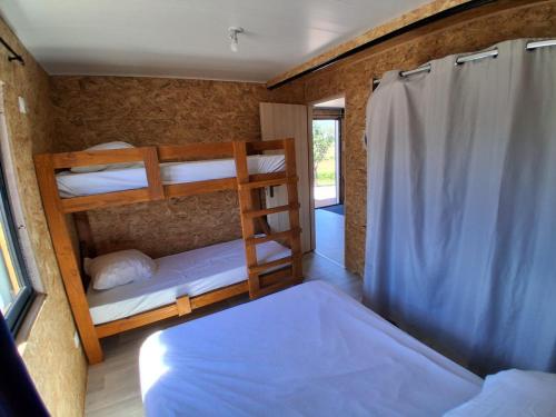 a room with three bunk beds and a window at Refuge climatisé tout proche du Pal in Le Pin