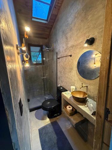 a bathroom with a sink and a toilet and a mirror at Floresta das Evas in Petrópolis
