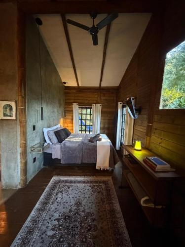 a bedroom with a bed and a window and a rug at Floresta das Evas in Petrópolis