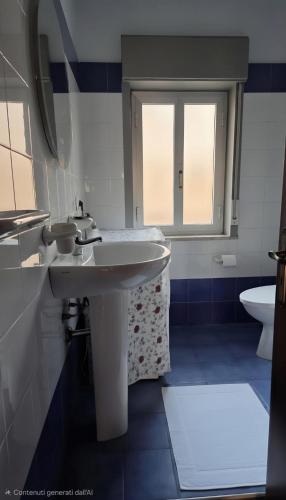 a bathroom with two sinks and a toilet at Marinello house in Oliveri