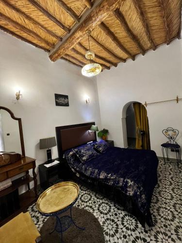 a bedroom with a bed and a wooden ceiling at Riad Le Lieu in Tiznit