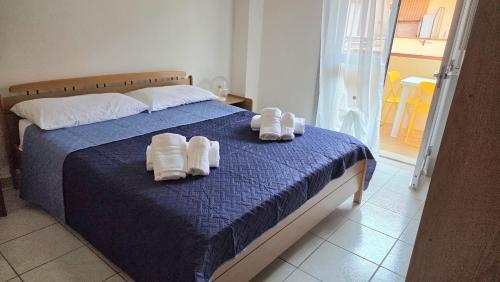 a bedroom with a bed with towels on it at Marinello house in Oliveri