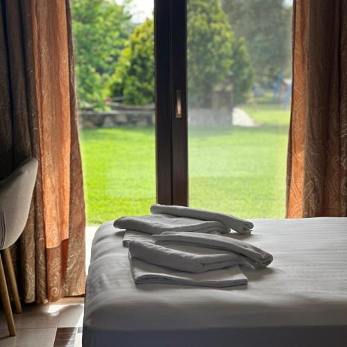 a group of tongs sitting on a bed in front of a window at Saint George Sithonia in Neos Marmaras