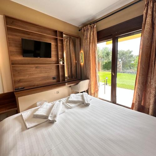 a bedroom with a bed with two white towels on it at Saint George Sithonia in Neos Marmaras