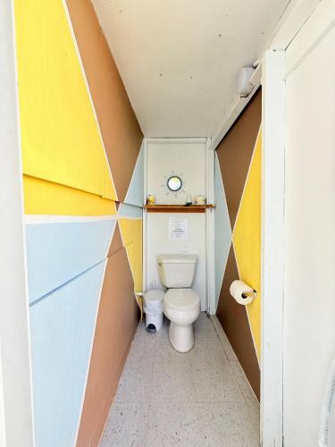 a bathroom with a toilet in a colorful wall at 2 Pools - Solar - Playa Santa - Apto E in Guanica