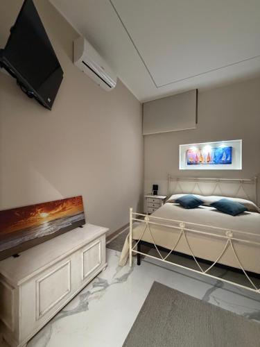 a bedroom with a bed and a tv on the wall at Catalano Suite Marina - Vista Mare in Palermo